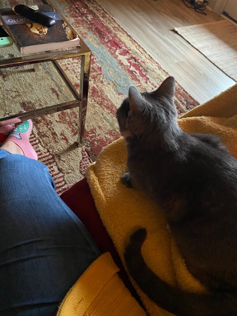 Briana sitting beside her cat Catticus